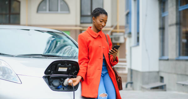 Young woman charging her EV
